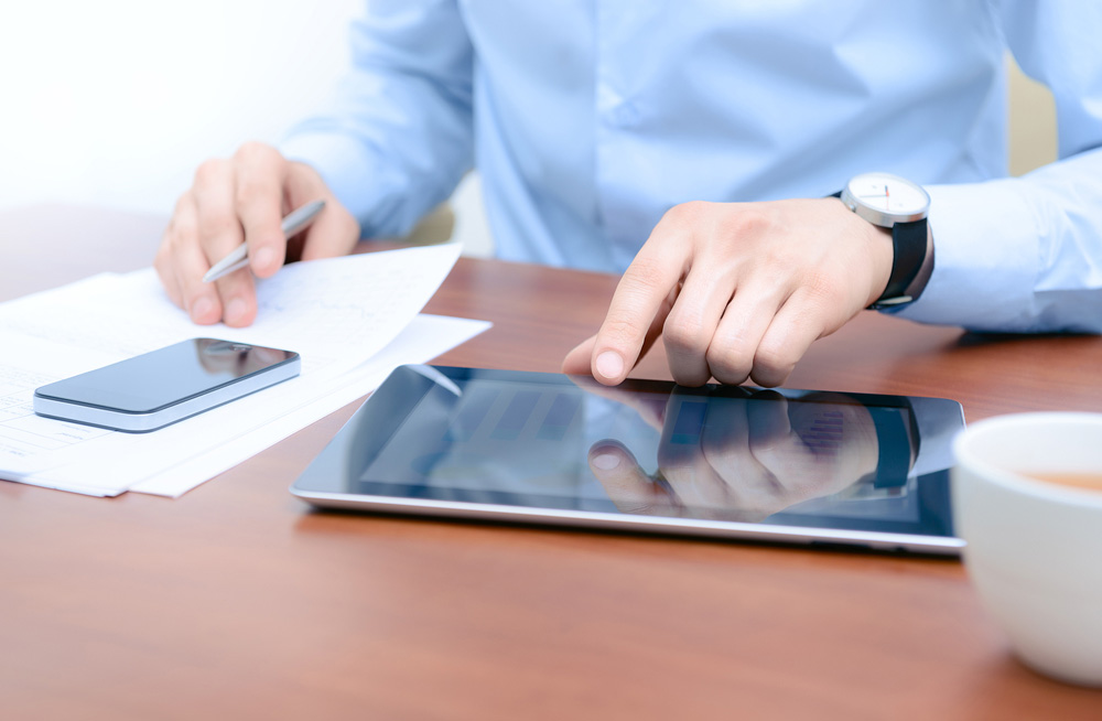 Small business accountant in Geelong office working on phone and ipad